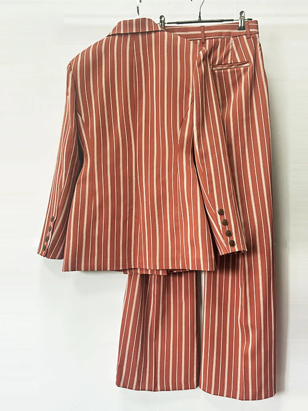 Back view of double breasted striped blazer and wide leg pants suit hanging