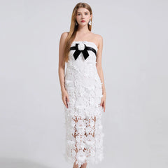 White lace dress with a black bow on a white background