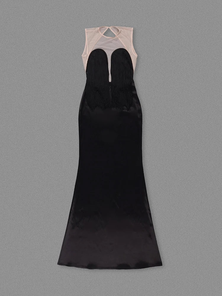 Black evening gown with sheer beige top on a gray background
