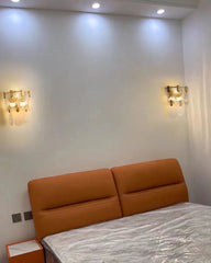 Orange bed with a white mattress in a room with wall lights.