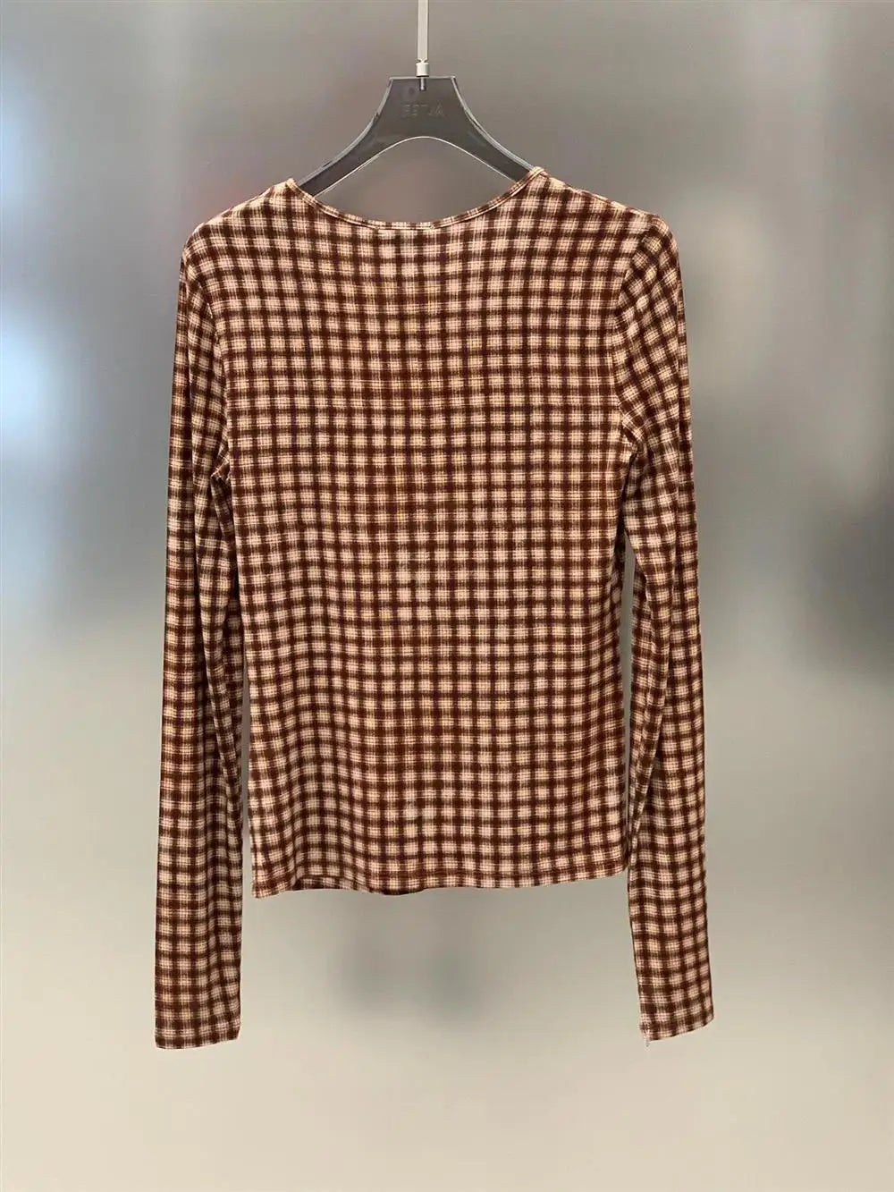 Back view of plaid fitted long sleeve top on hanger