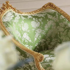 Decorative chair with gold frame and green floral pattern- close-up