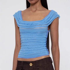 Woman wearing a blue ruffled top against a white background