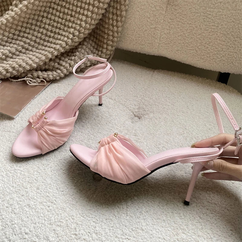 Close-up of a pink stiletto heel sandal with ruched mesh detail
