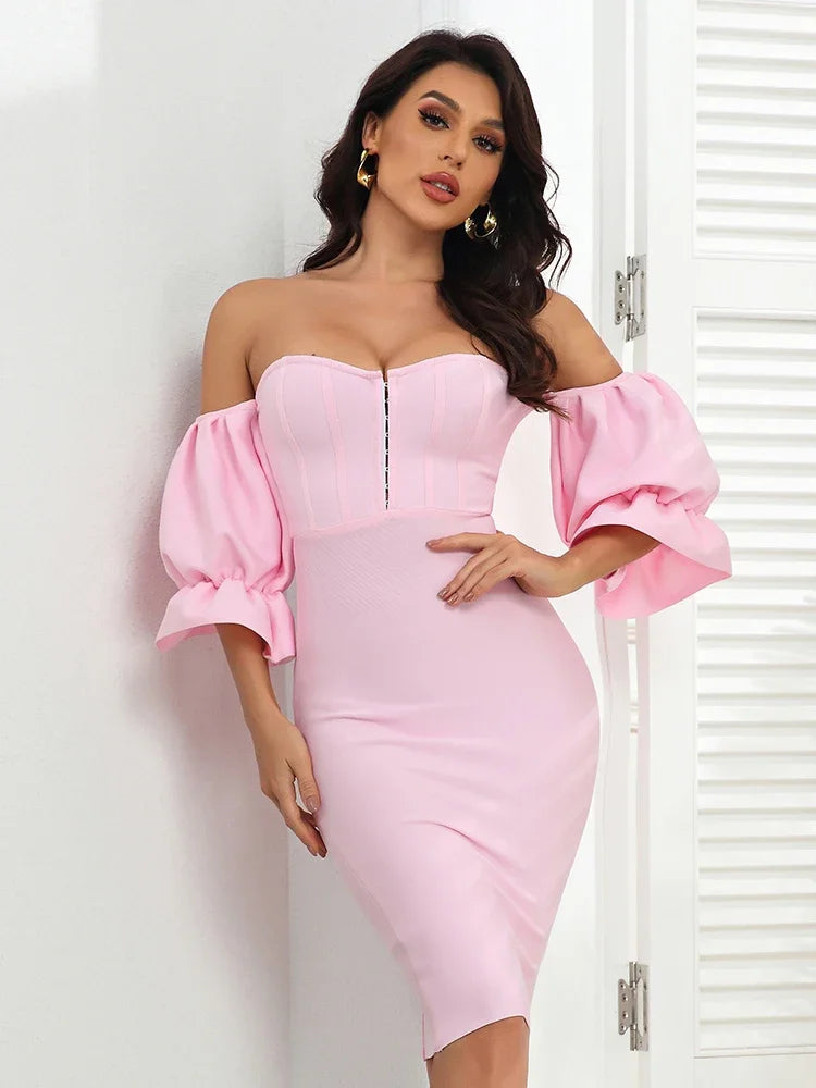 Woman wearing a pink off-shoulder dress with puffed sleeves against a white background