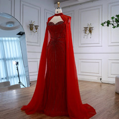 Red evening gown with a cape on a mannequin against a white wall.