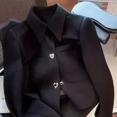 Black blazer with heart-shaped buttons on a chair
