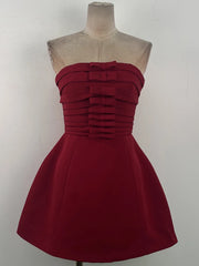 Red strapless dress on a mannequin against a white background