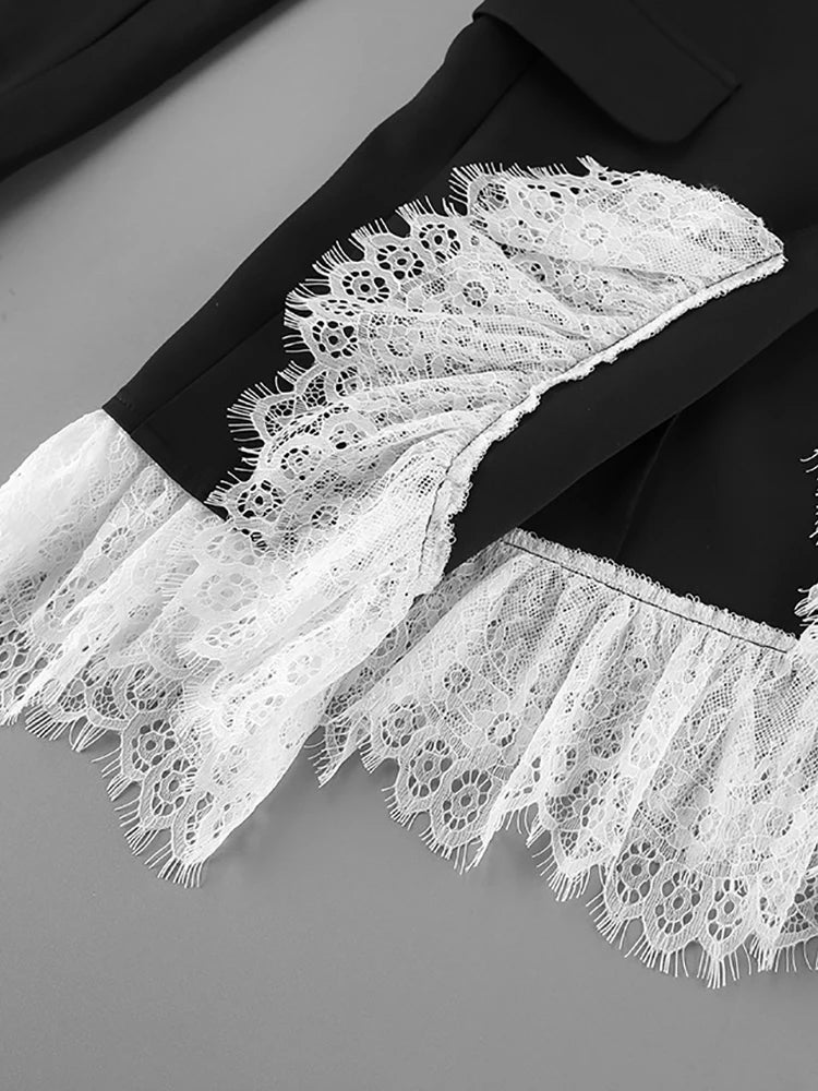 Close-up of a black garment with white lace detailing on a gray background