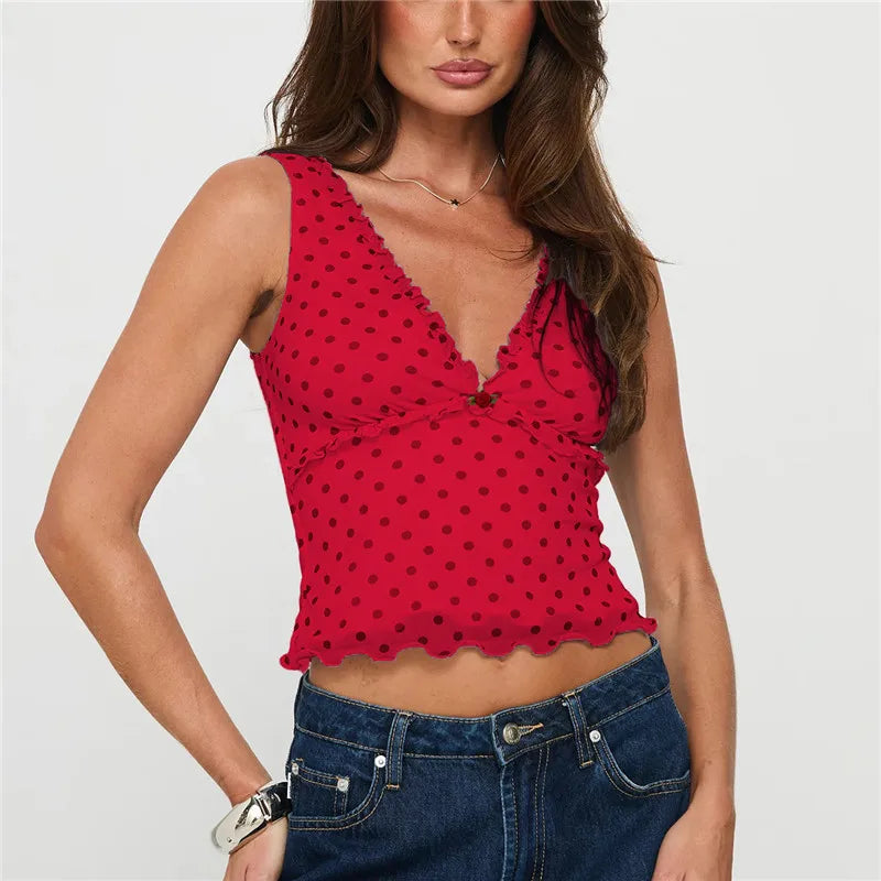 Woman wearing a red polka dot top and blue jeans on a white background