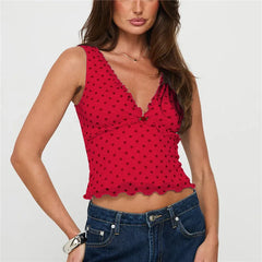 Woman wearing a red polka dot top and blue jeans on a white background