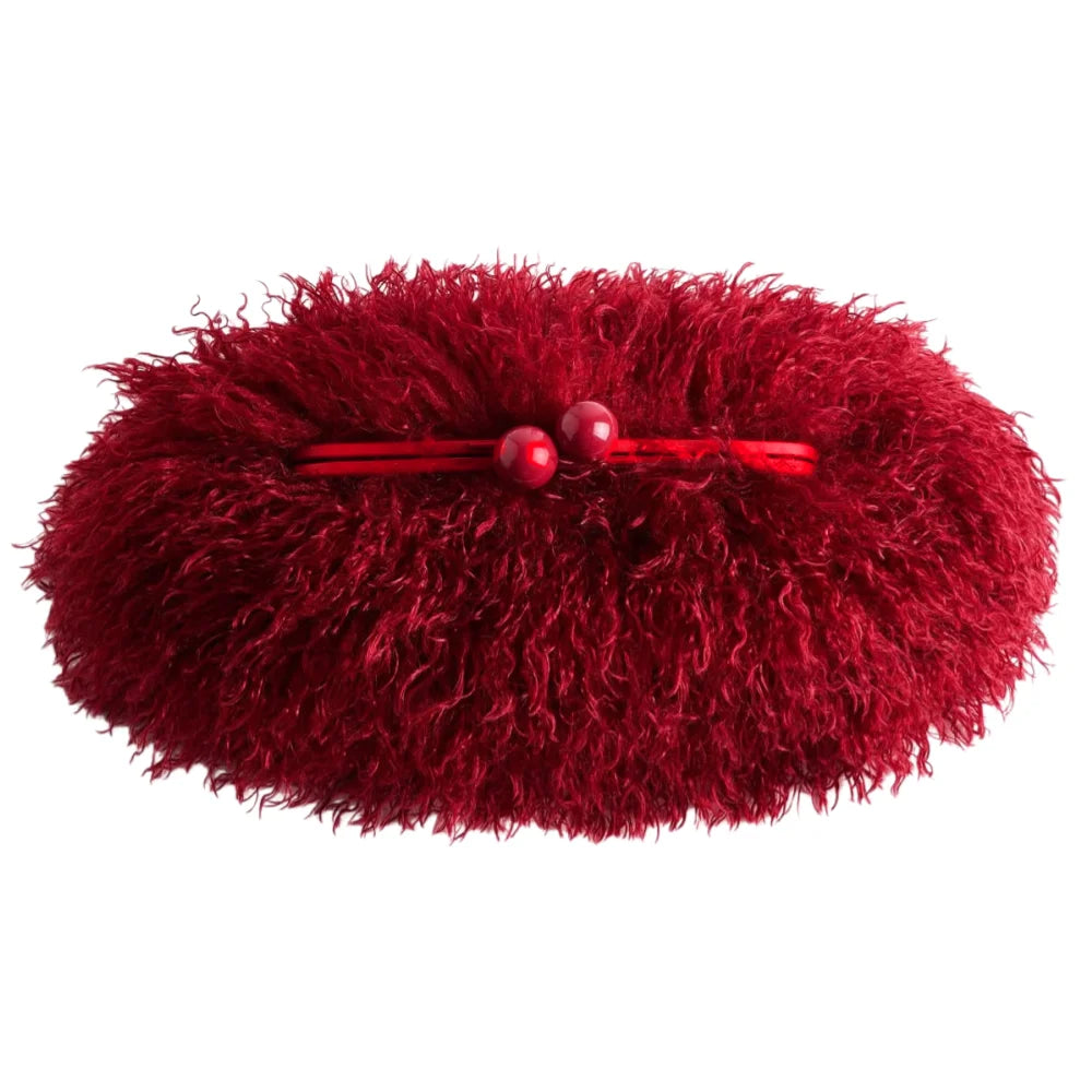 Red fluffy clutch with a hair clip on a white background
