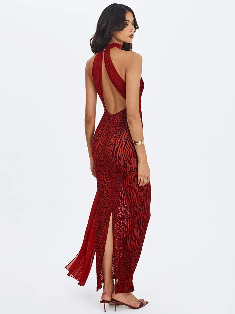 Woman wearing a red open-back dress with a slit on a white background