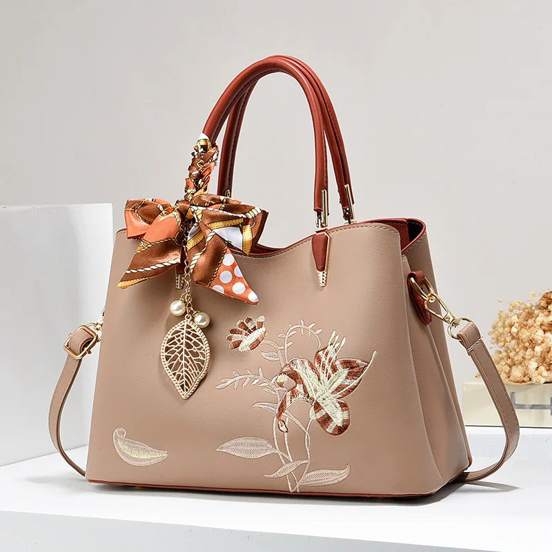 A luxurious embroidered leather shoulder bag with intricate detailing, showcased against a neutral background.