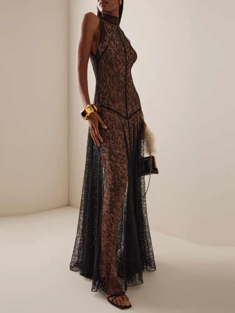 Woman wearing a black lace dress against a plain background