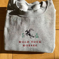 Women's sweatshirt with a cactus and "Hold Your Horses" embroidery.