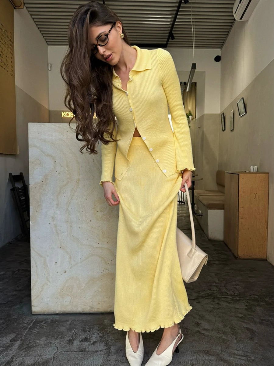 Woman in a yellow suit standing in an indoor setting