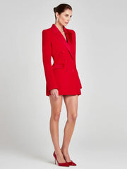 Woman wearing a red blazer dress on a light gray background