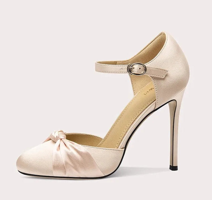 Beige high-heeled shoe with a bow detail on a white background