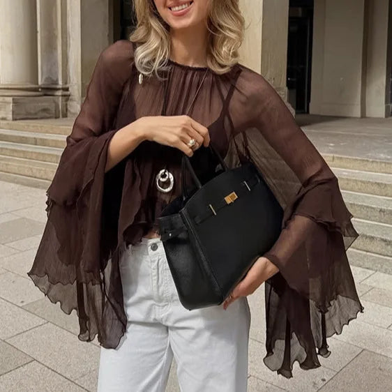 Woman holding a black handbag in an urban setting