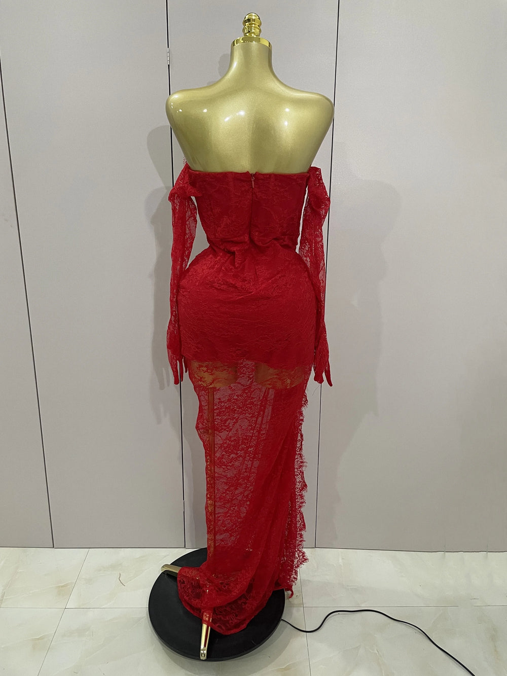 Red lace dress on a mannequin against a white wall