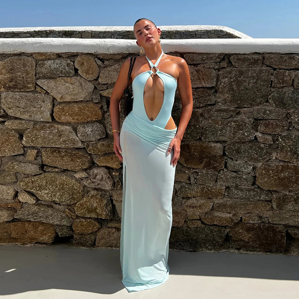 Front view of monochrome one-piece swimsuit with maxi skirt against stone wall