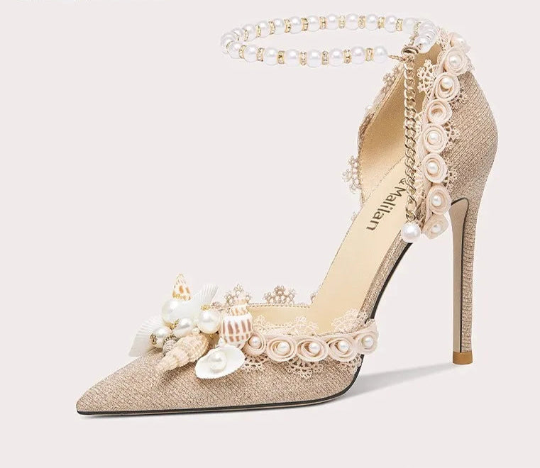 High-heeled shoe with floral and pearl details on a light gray background