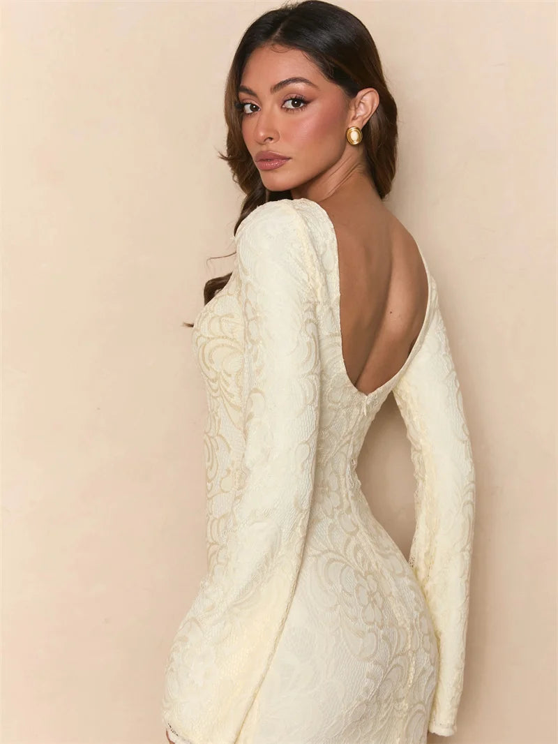 Woman wearing a white lace dress with long sleeves on a beige background