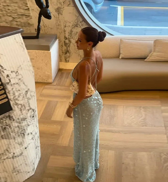Woman in a stylish outfit standing in a modern living room.
