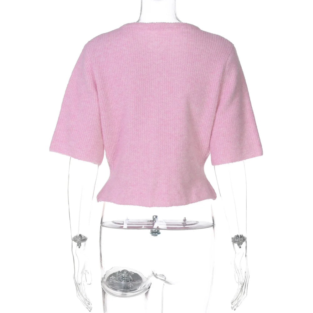 Pink ribbed sweater on a mannequin against a white background
