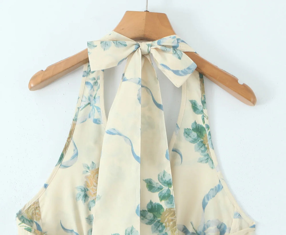 Beige halter top with floral pattern on a wooden hanger against a white background