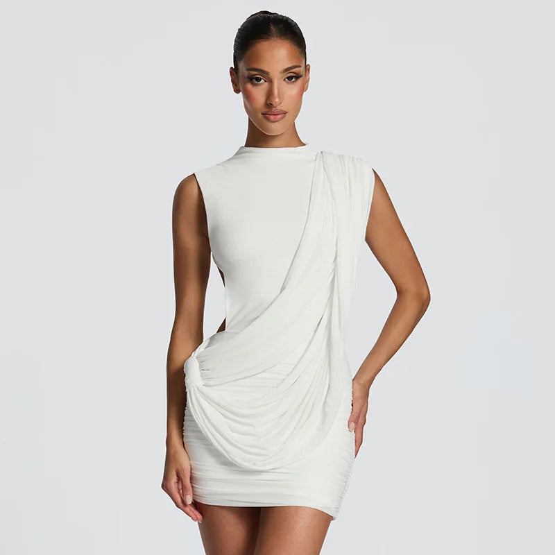 Woman wearing a white draped dress against a plain background