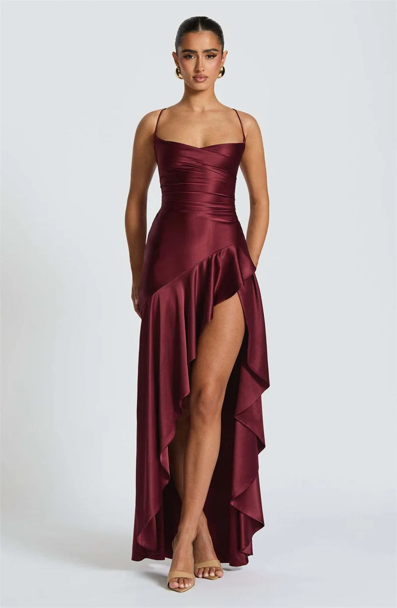 Woman wearing a burgundy evening gown with a slit on a white background