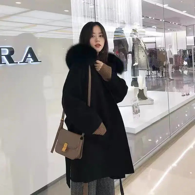 Person wearing a black coat with fur hood in a store setting