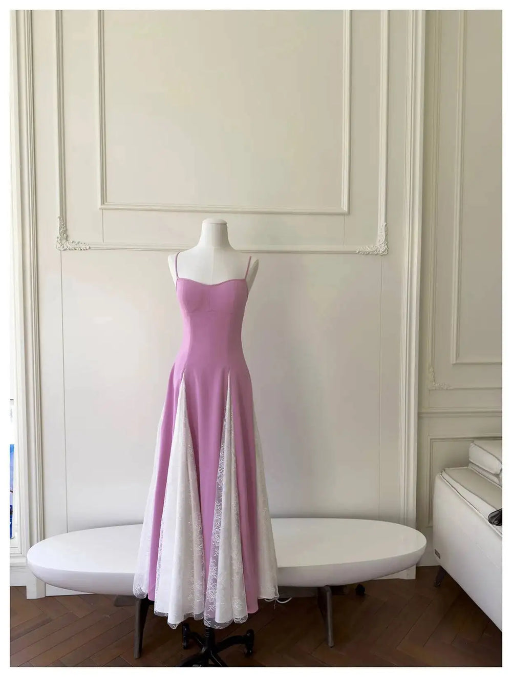 Back view of a pink A-line midi dress, showcasing the lace-up closure and spaghetti straps.