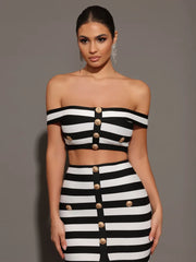 Woman wearing a black and white striped outfit with gold buttons against a gray background