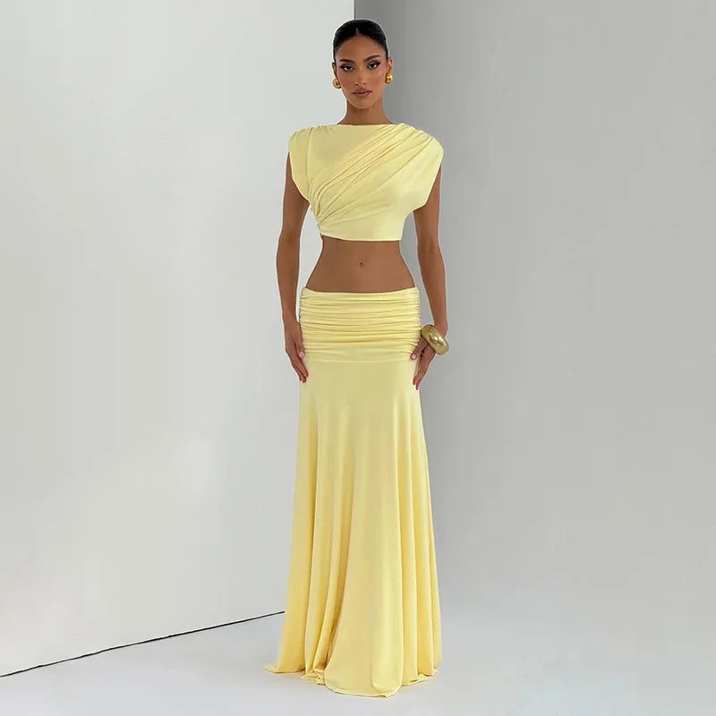 Woman wearing a yellow two-piece outfit against a plain background