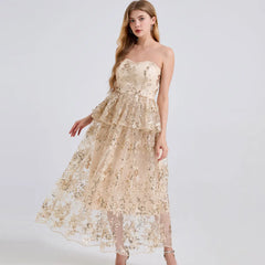 Woman wearing a beige strapless lace dress on a white background