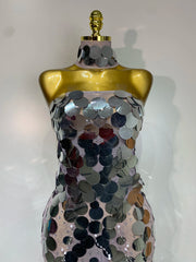 Mannequin wearing a dress with silver sequins on a white background