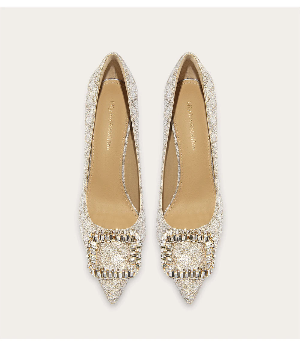 Pair of embellished high-heeled shoes on a light background