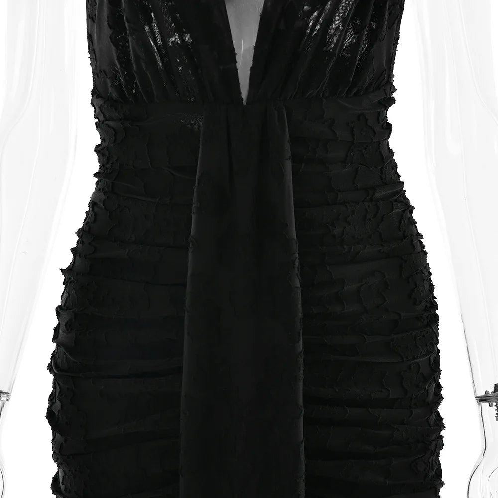 Black dress with ruffled details on a white background