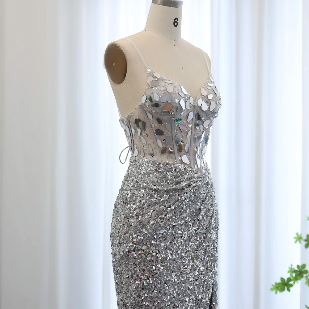 Silver sequin dress on a mannequin against a white curtain background