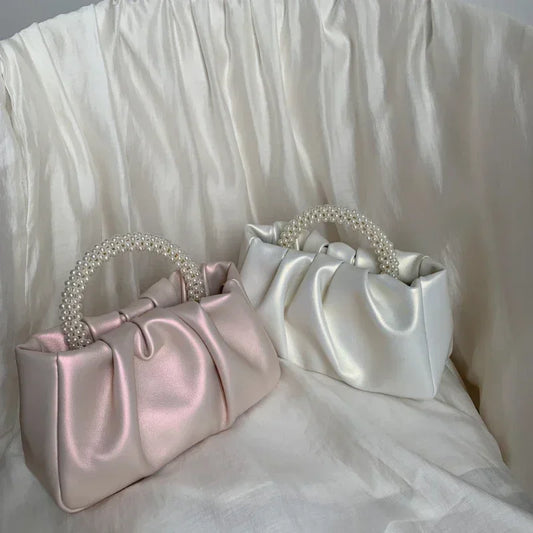 Pink gathered clutch bag with a pearl handle
