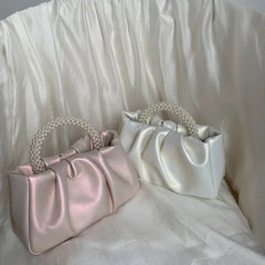 Pink gathered clutch bag with a pearl handle