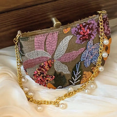 A stunning sequin clutch bag with a pearl chain strap and flower embellishments, perfect for a wedding or special occasion.