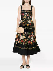 Black floral print square neck sleeveless A-line midi dress with a gathered hem worn by a model holding a clutch.