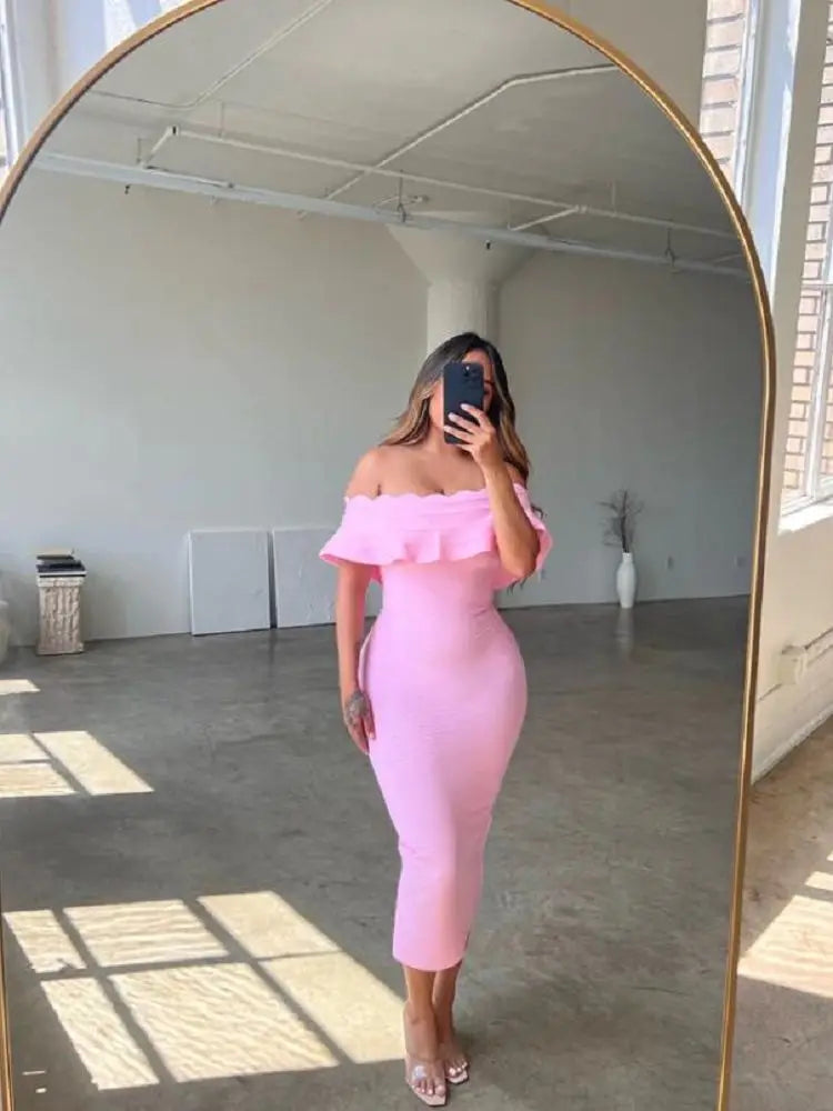 Person wearing a pink off-shoulder dress standing in front of a mirror.