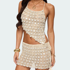 Woman wearing a beige crochet top and skirt set on a plain background