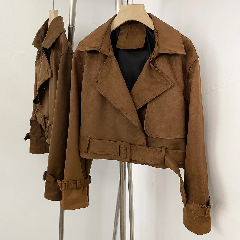 Brown faux leather cropped jacket hanging on a rack