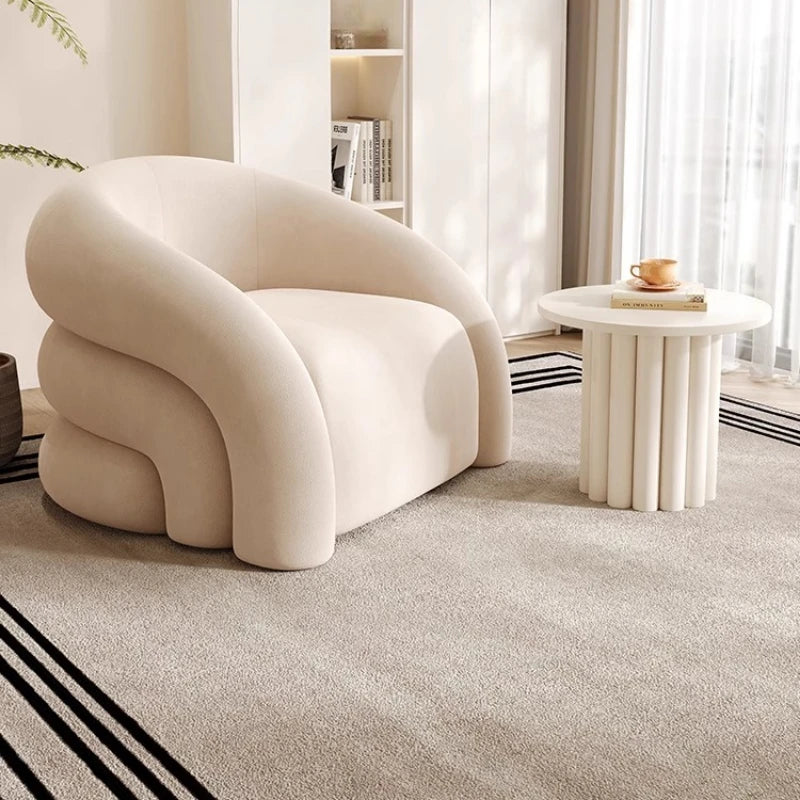 Modern beige lounge chair in minimalist living room with curved design